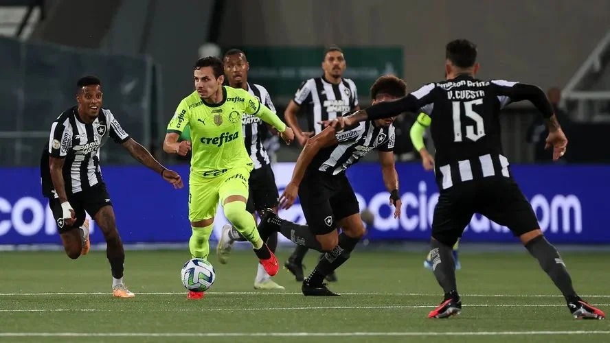 Veiga em ação observado por jogadores do Botafogo / Foto: Cesar Greco